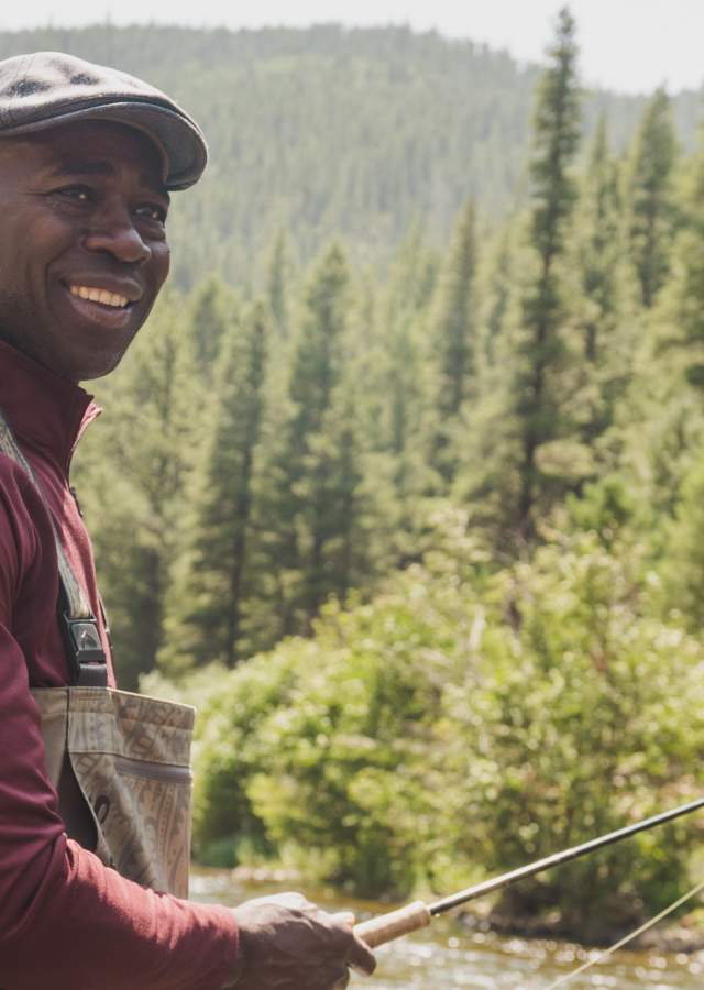 A person fly-fishing in a stream near Denver, Colorado.