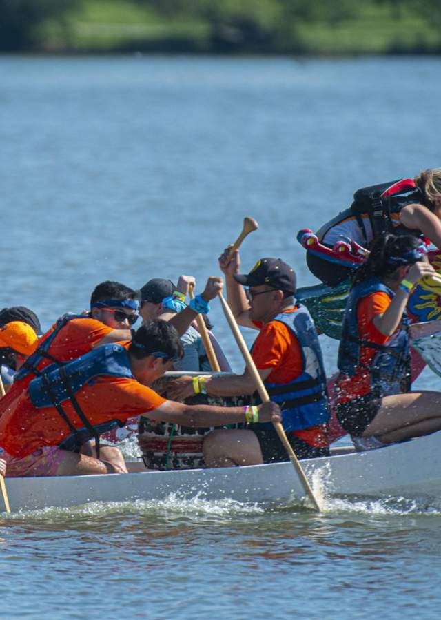 A dragon boat team paddles on a reservoir in Denver