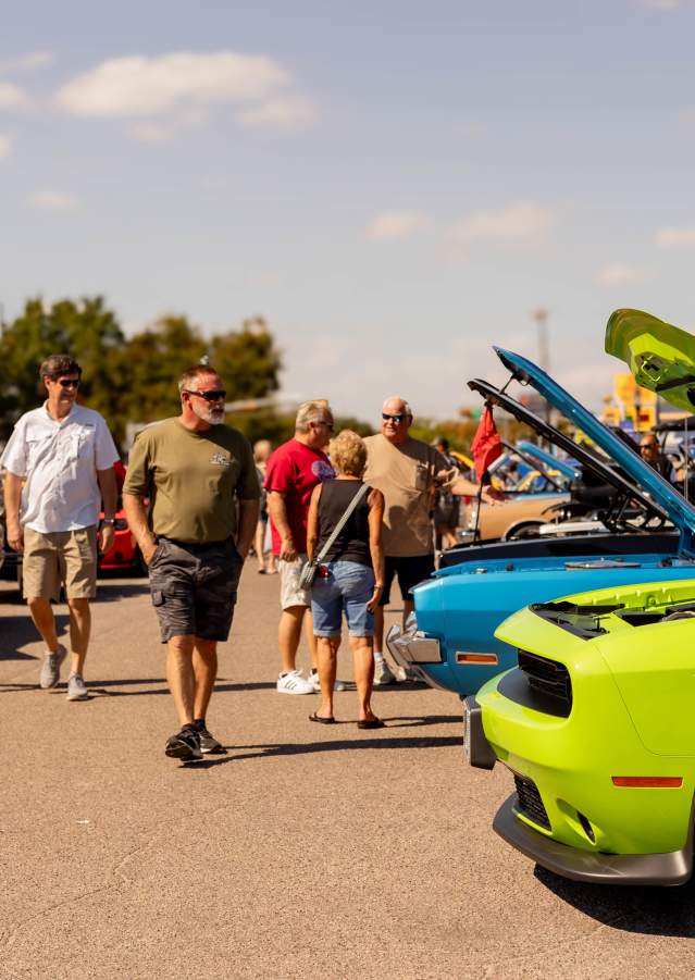 People viewing classic cars lined up during a Downtown Denison car show event