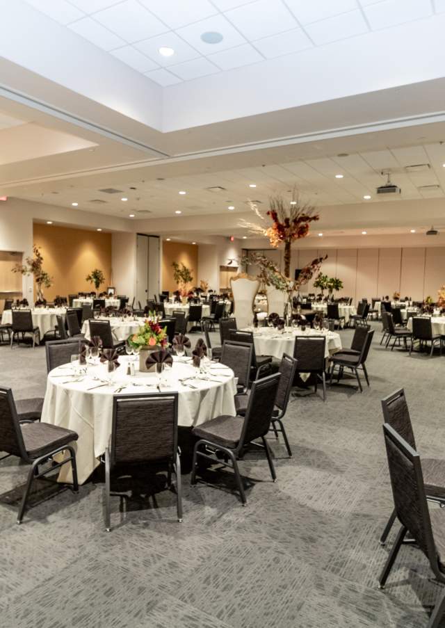 Wide view of banquet setup inside the Rocky Mount Event Center in Rocky Mount, North Carolina with round tables and elegant event décor.