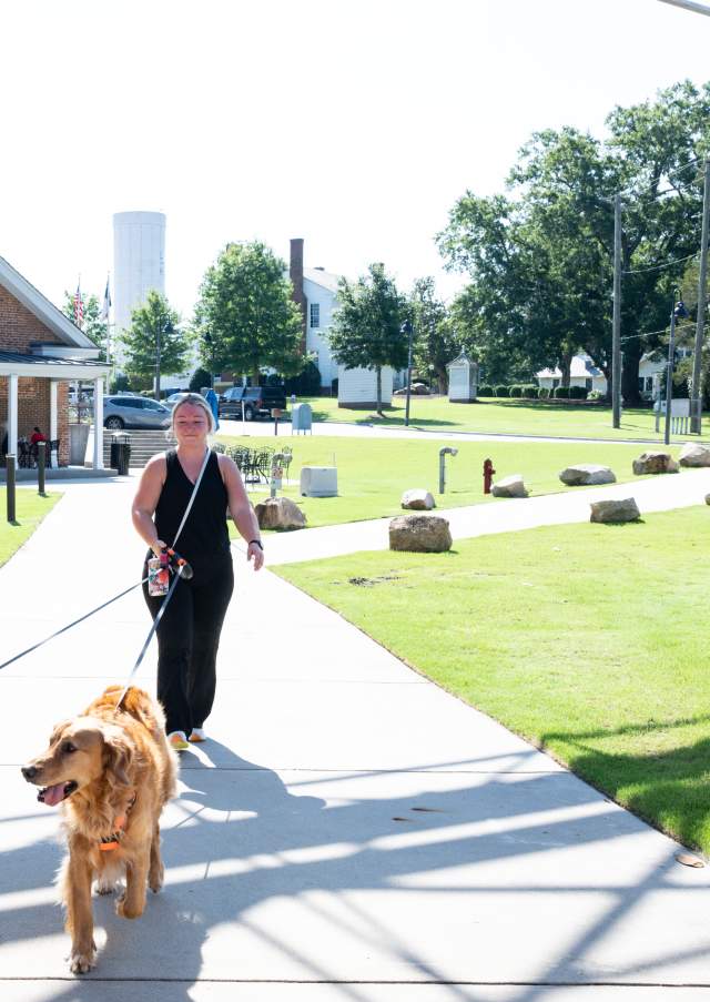 Woman walking two dogs at the Rocky Mount Mills in Rocky Mount, North Carolina