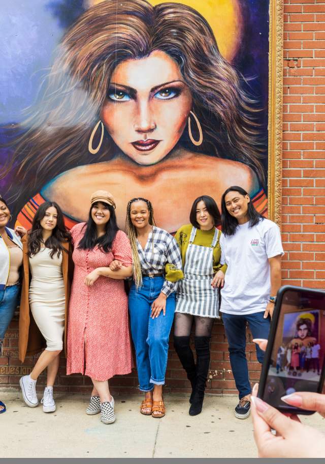 Group standing in front of mural