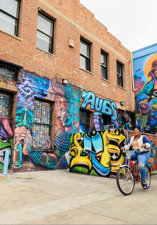 Girls riding bikes past murals