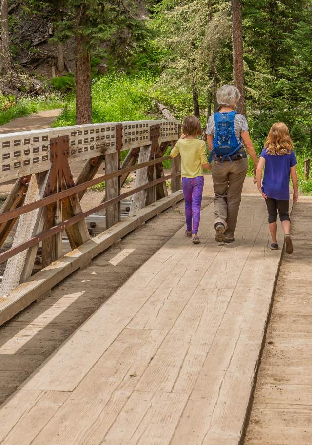 Group of 3 walking over the Ousel Falls Bridge
