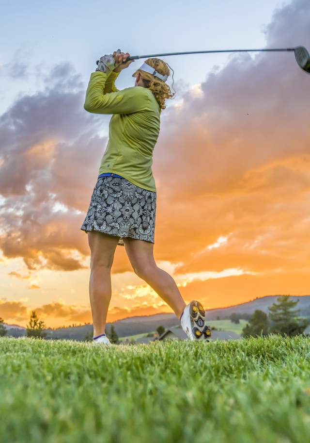 Women golfing with sunset