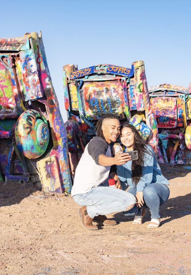 Couple taking a selfie in front of cadillac ranch in Amarillo, texas