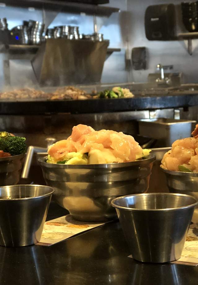 bowls of meat and vegetables ready for a hibachi grill