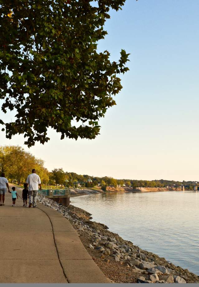 family walking along a riverwalk in the early fall