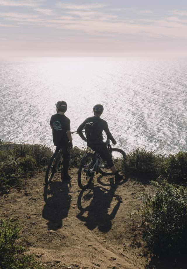 image of two moutntain bikers overlooking pacific ocean