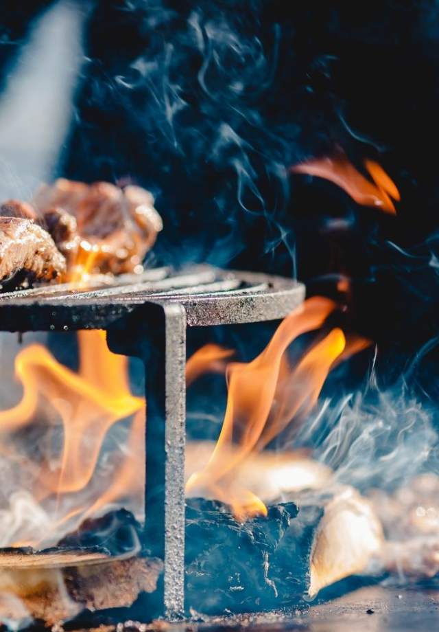 Man cooking meat over fire