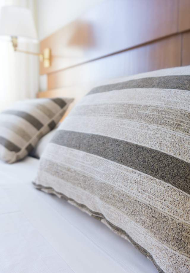 Pillows-on-top-of-a-bed-inside-a-hotel-room