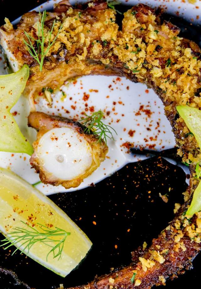 Indian inflected preparation using South Asian spice crusting techniques on a Western style whole cut of seafood, finished with bright, acidic garnishes.