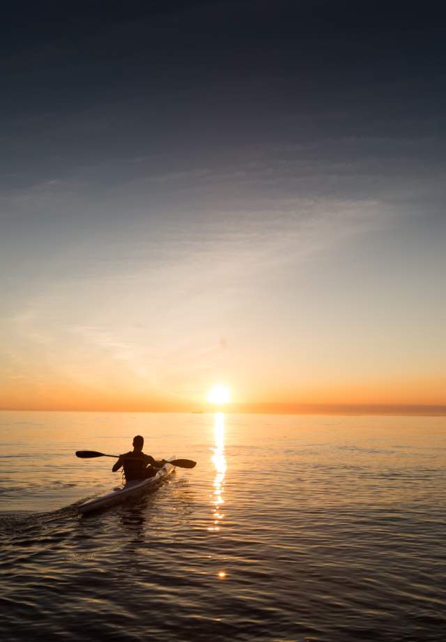 Man-kayaking-on-the-bay-during-the-sunset