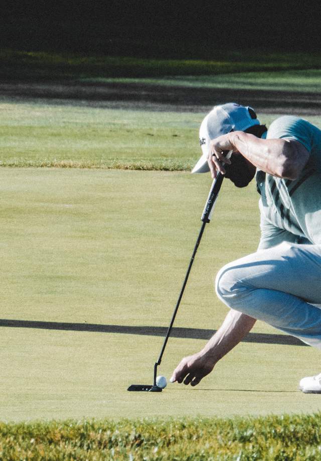 Man-placing-golf-ball-on-the-grass