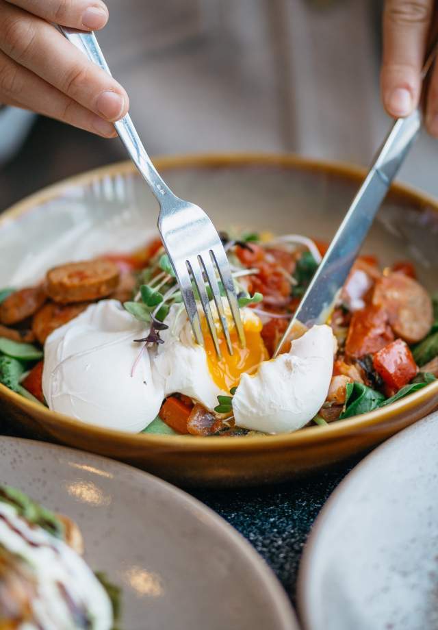 Person enjoying a delicious brunch meal