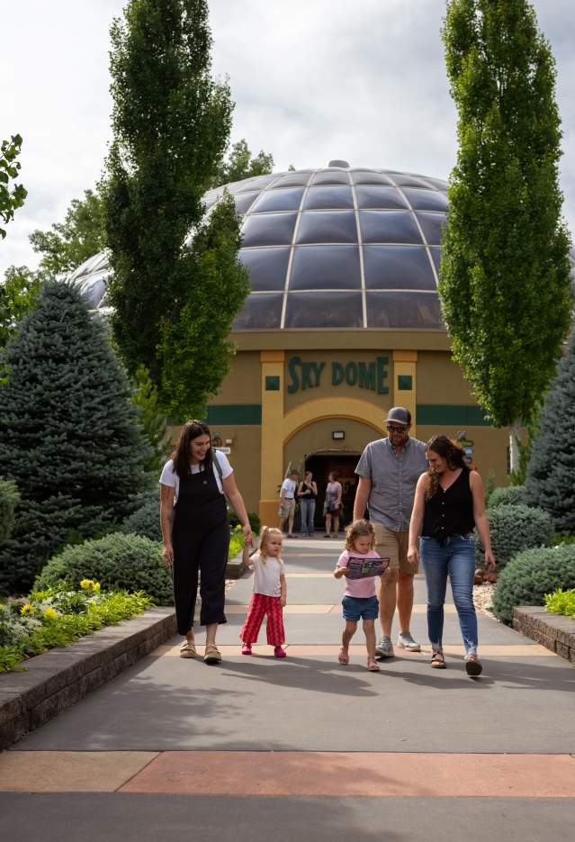 A family with children walking in front of the Reptile Gardens Sky Dome