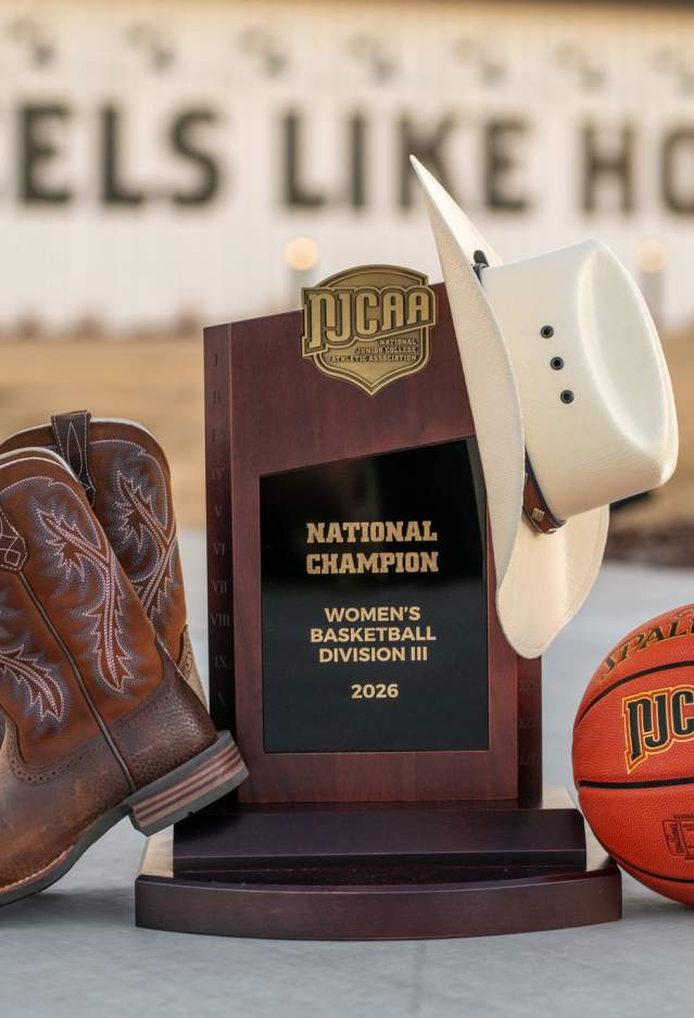 NJCAA Trophy decorated with boots, a cowboy hat, and the game ball outside of the Brownwood Event Center