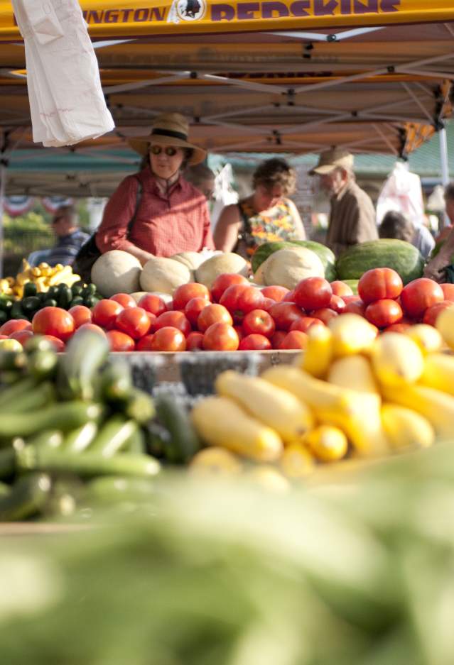 people shopping for fruits and vegetables at a farmers market