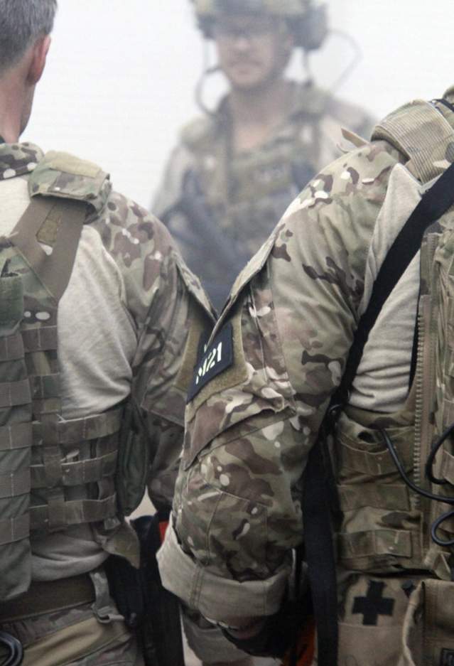 Men wearing camouflage with the letters "FBI" stitched on their uniforms