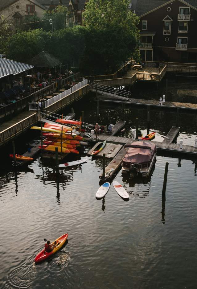 A boardwalk with kayaks and a few pontoon boats