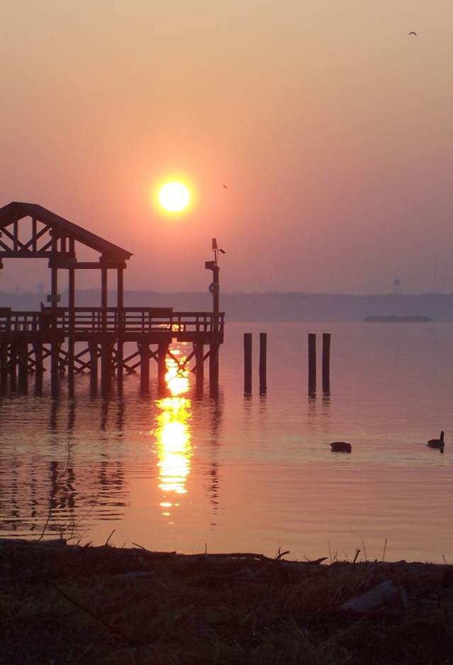 A beach with a boardwalk at sunset