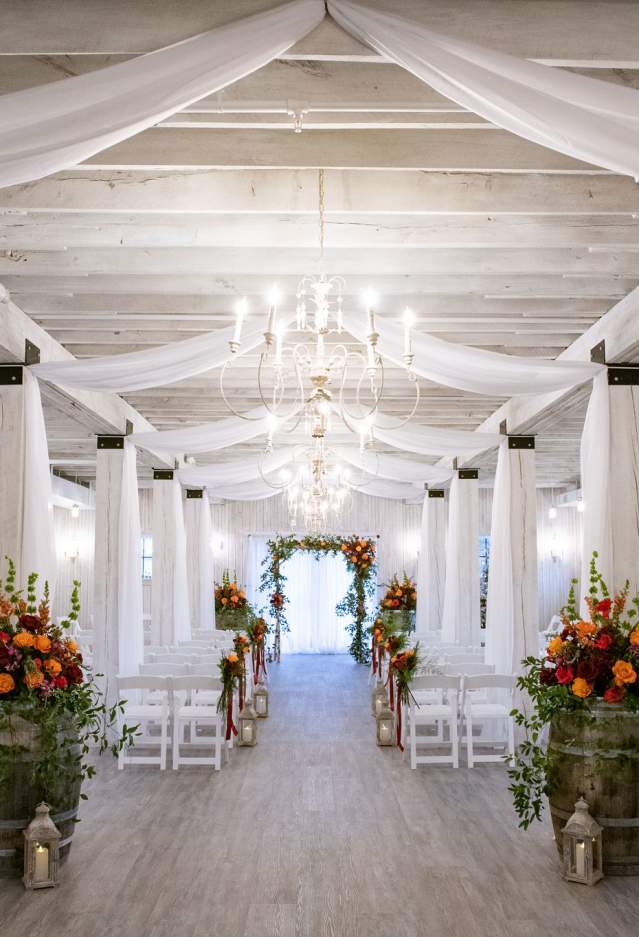 Sweeney Barn decorated with drapery, chairs and flowers for a wedding