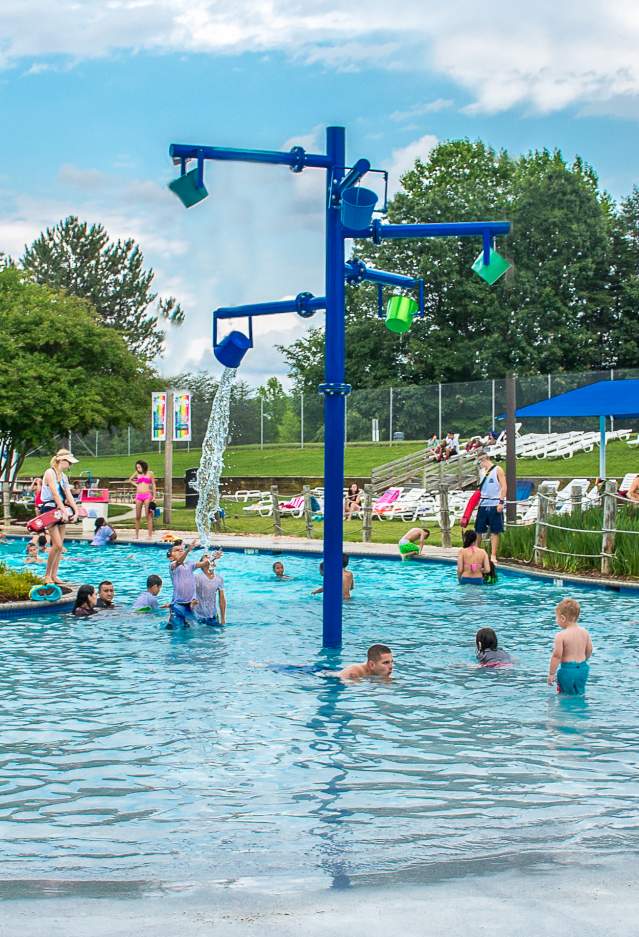 Lifeguards watching over a pool filled with guests in the summer