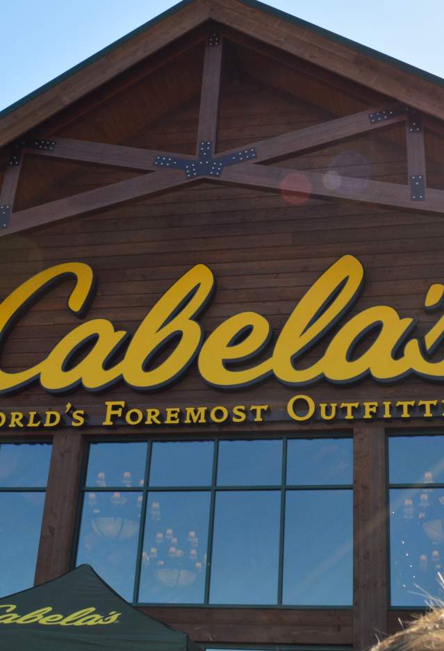 "Cabela's World's Foremost Outfitters" is written in yellow on the storefront of a brown building