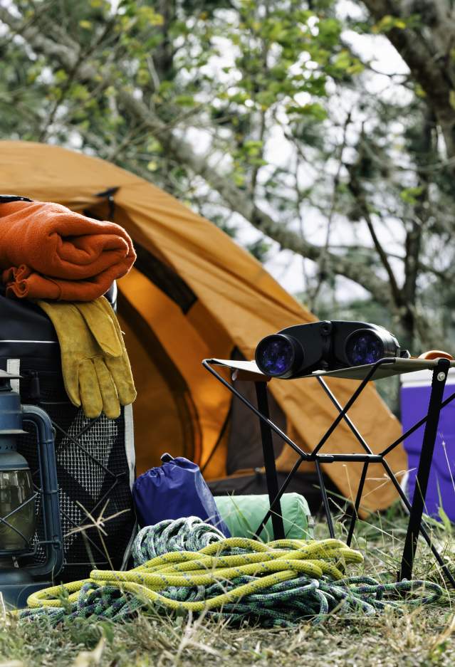 Camping gear in front of a tent in a forest