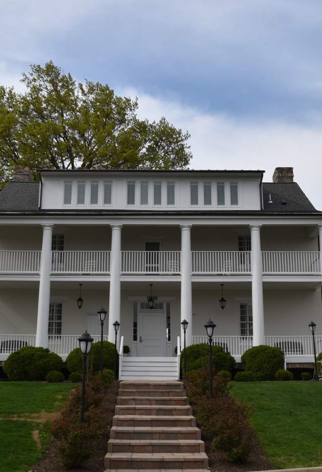 A white and cobblestone building with stairs leading to a door