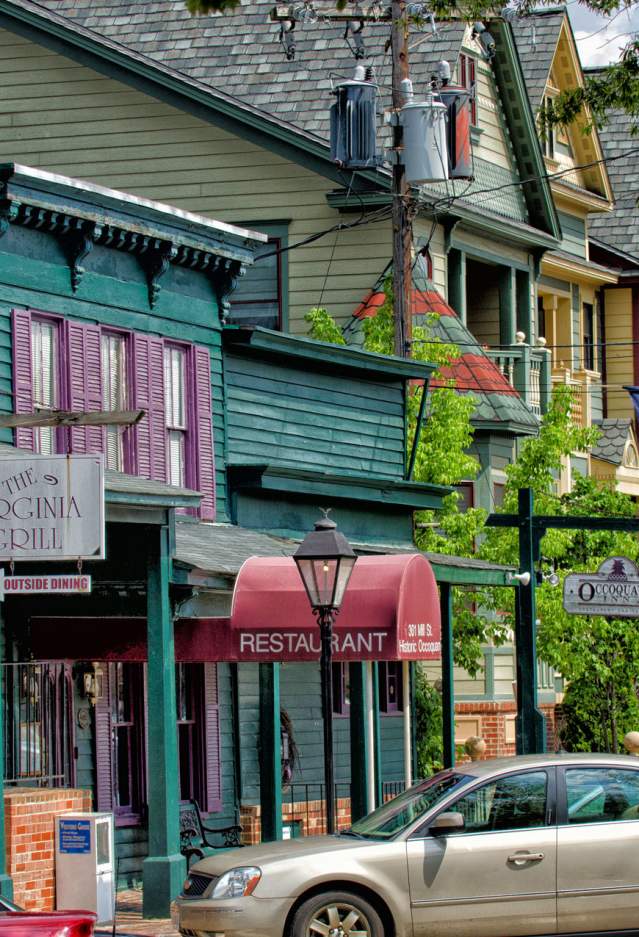 Colorful historic storefronts with cars parked outfront