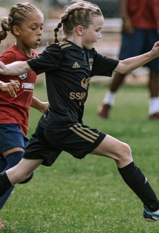 Two girls playing soccer