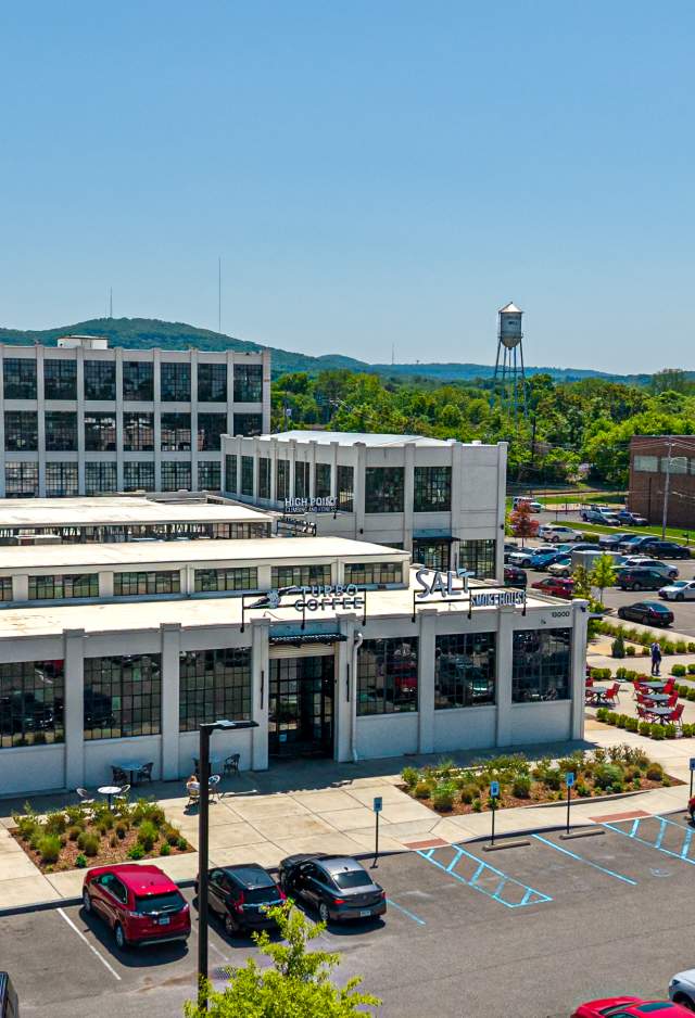 Aerial image of Lincoln Mill business district with mountains and the Lincoln Mill water tower in the background on a bright, sunny day.