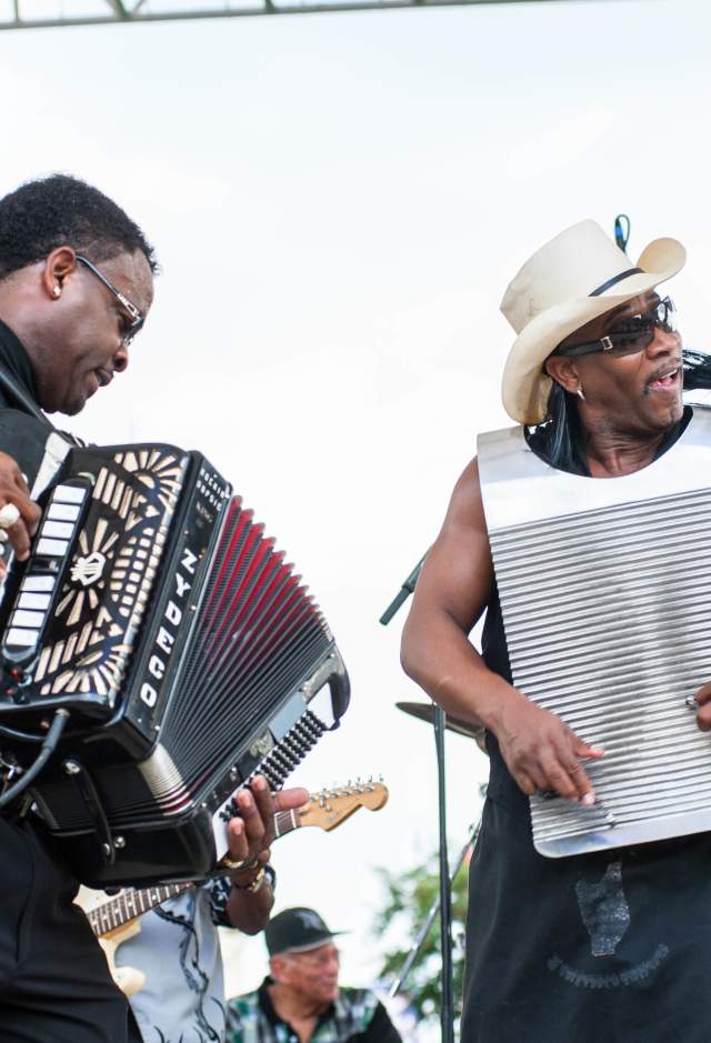 Accordion musician and singer performing on outdoor stage during a festival in Baton Rouge