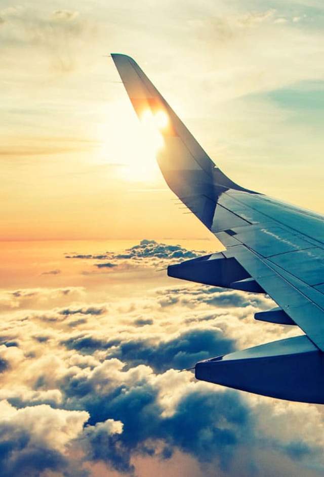 getting here milwaukee airport airplane wing in sunset sky