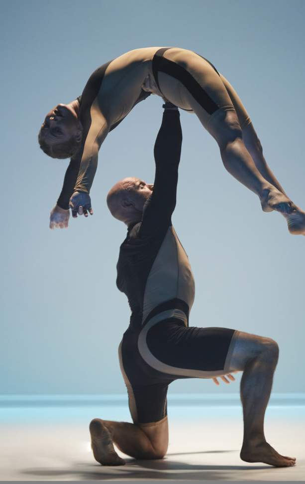 Image shows two Circa acrobats performing a lift on a blue background.