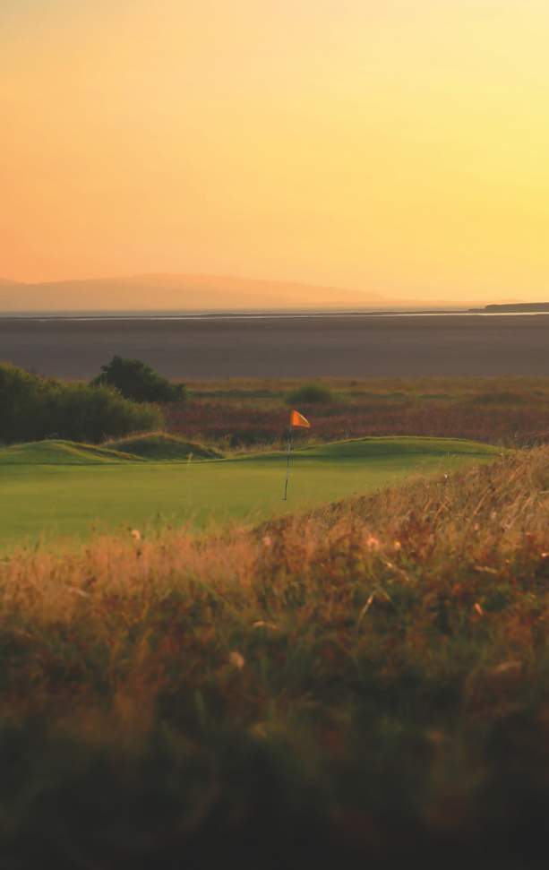 An orange sunset in the Wirral Hills looking across a green golf course