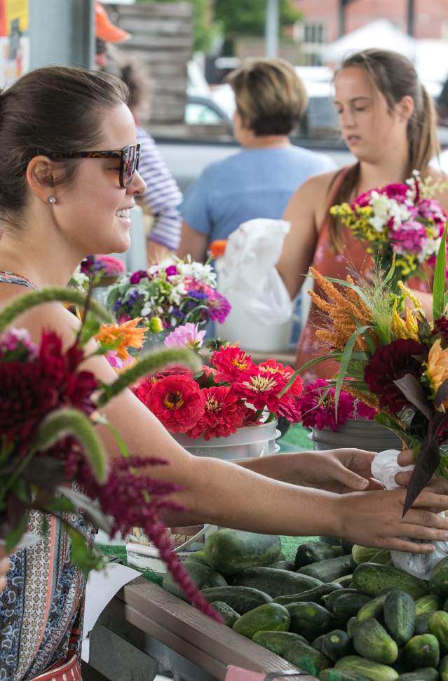 Two women, buying flowers at stand
