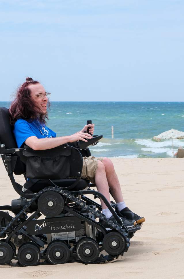 Person in motorized beach wheelchair. lake michigan in background