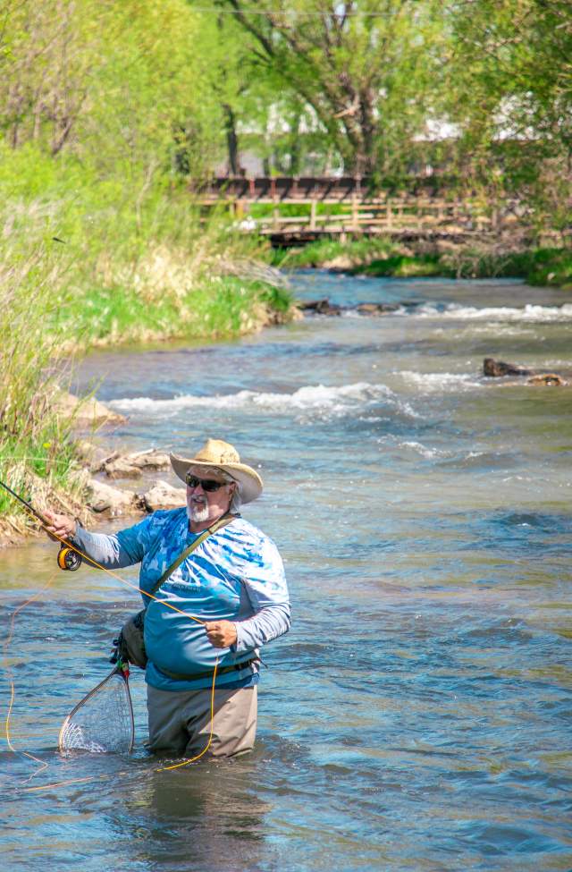 man fly fishing in the waters of rapid creek found in rapid city, sd