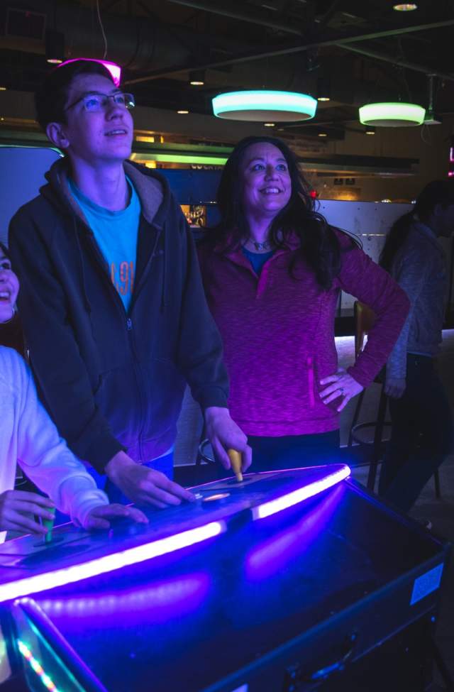 family playing the pac man game at press start arcade and bar in downtown rapid city, sd