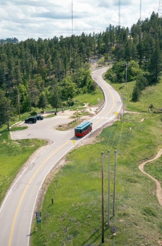 green and red trolley driving on the scenic road skyline in rapid city, sd