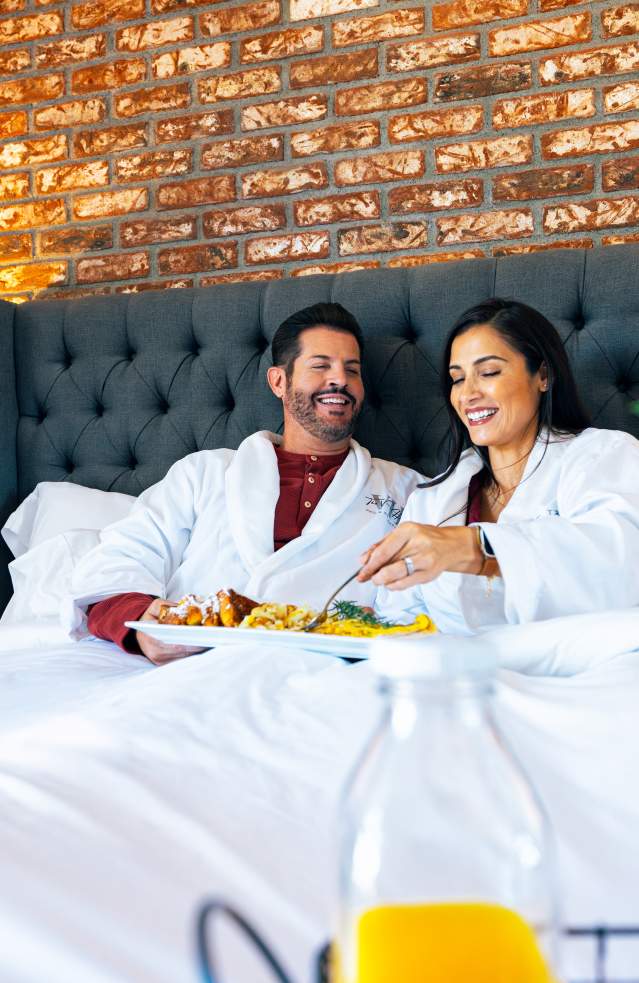 Couple enjoying breakfast in bed at the Vine House in Temecula