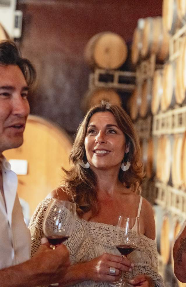 Couple and a few friends wine tasting in the barrel room at Ponte Vineyard in Temecula