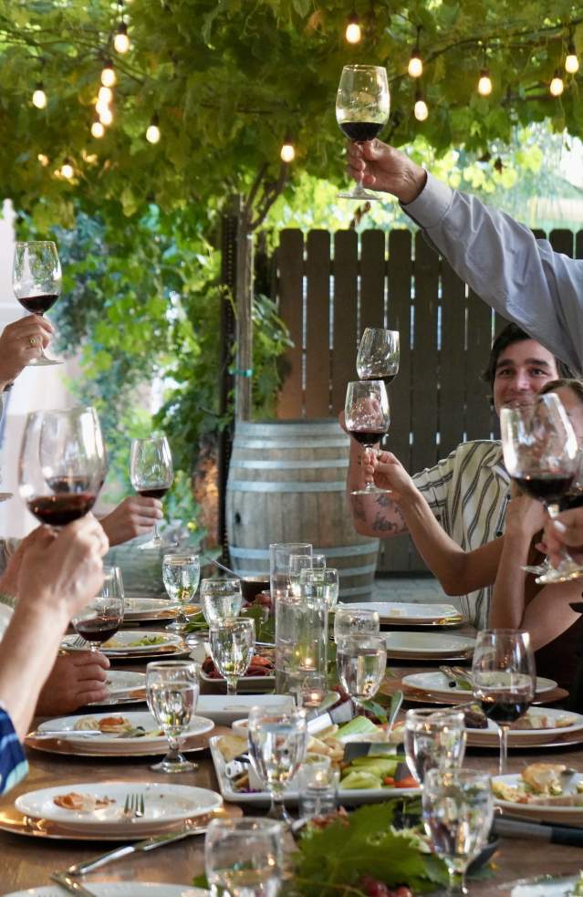 Several people raise their glasses at a table