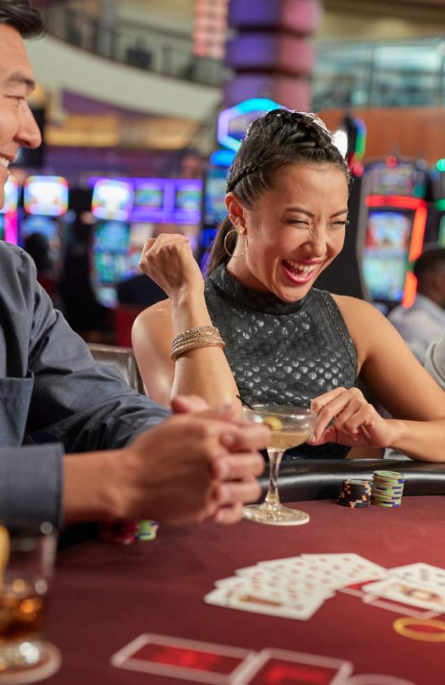 Several friends sit at a casino table playing poker