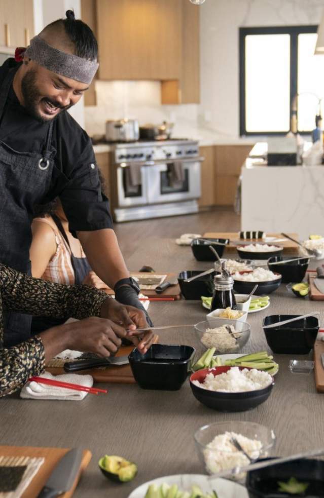 Several people enjoy a meal prepared by a private chef