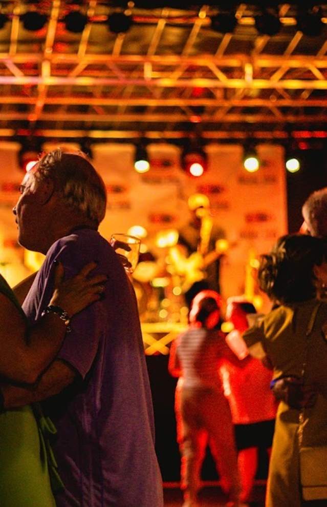 couples dancing in front of stage, nighttime