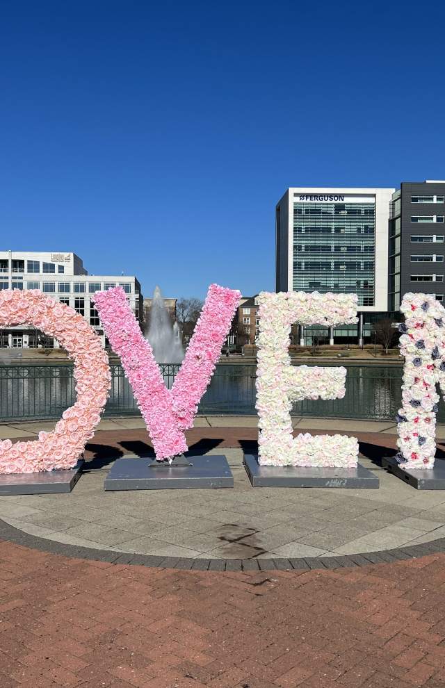 A sign that reads: LOVE NN decorated in pink and white flowers