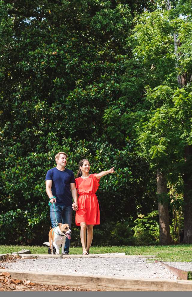 Couple walking dog on a trail